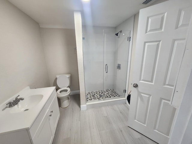 bathroom featuring hardwood / wood-style flooring, vanity, toilet, and an enclosed shower