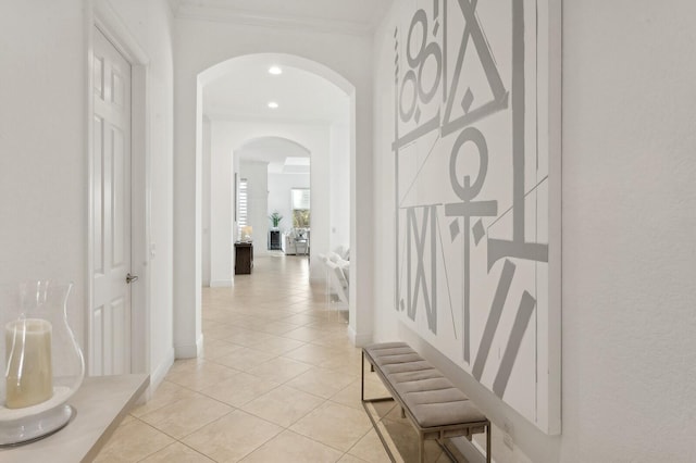 hallway featuring ornamental molding and light tile patterned flooring