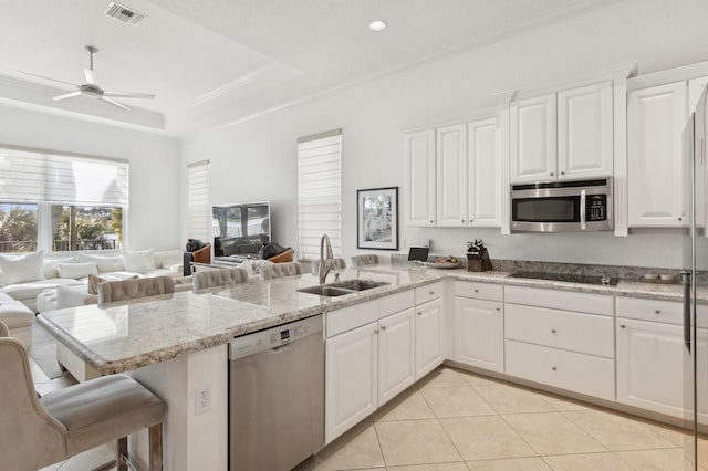 kitchen featuring kitchen peninsula, appliances with stainless steel finishes, white cabinetry, and sink