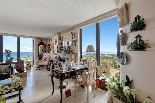 dining room with floor to ceiling windows, a water view, and a textured ceiling