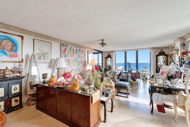 living room featuring expansive windows, ceiling fan, a water view, and a textured ceiling