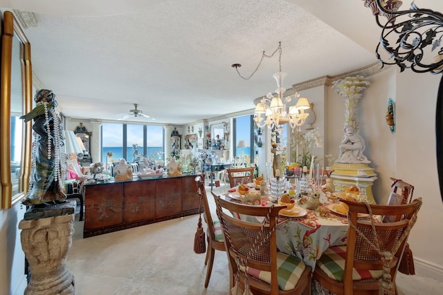 dining room featuring ceiling fan with notable chandelier, expansive windows, and a textured ceiling