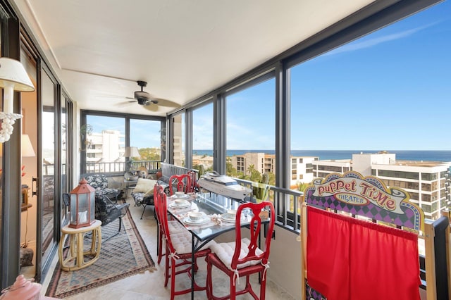 sunroom / solarium featuring a water view and ceiling fan