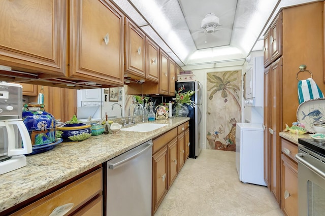 kitchen featuring ceiling fan, light stone countertops, sink, and appliances with stainless steel finishes