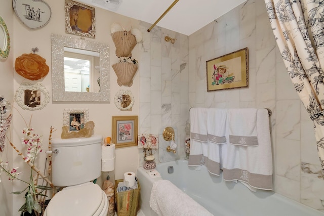 bathroom featuring shower / tub combo and toilet