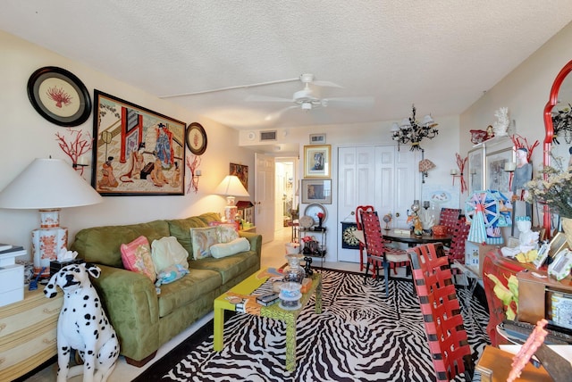 living room featuring ceiling fan and a textured ceiling