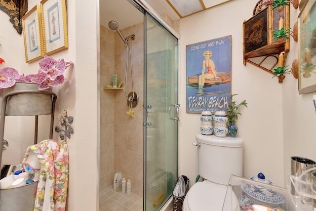 bathroom featuring toilet and a shower with door