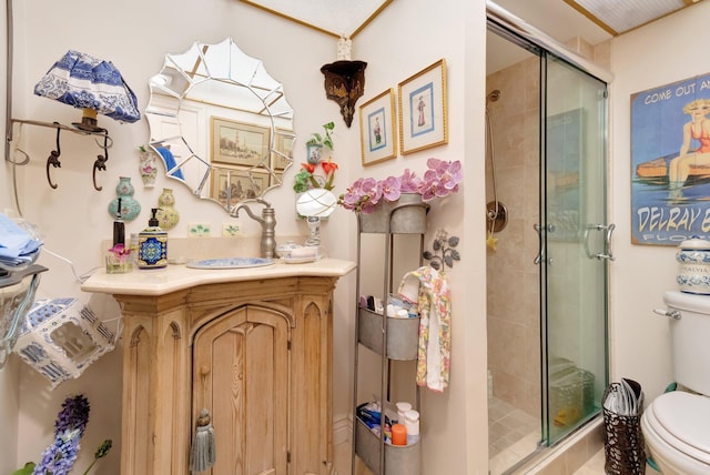 bathroom featuring a shower with door, vanity, and toilet