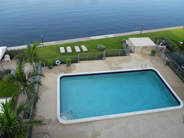 view of swimming pool with a patio area and a water view