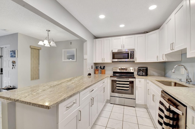 kitchen with sink, white cabinetry, hanging light fixtures, appliances with stainless steel finishes, and kitchen peninsula