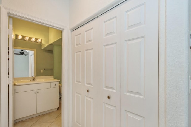 bathroom featuring toilet, vanity, tile patterned floors, and ceiling fan