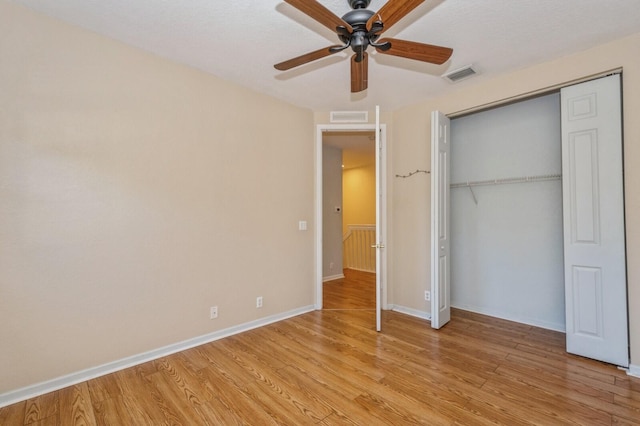 unfurnished bedroom featuring a closet, light hardwood / wood-style flooring, and ceiling fan