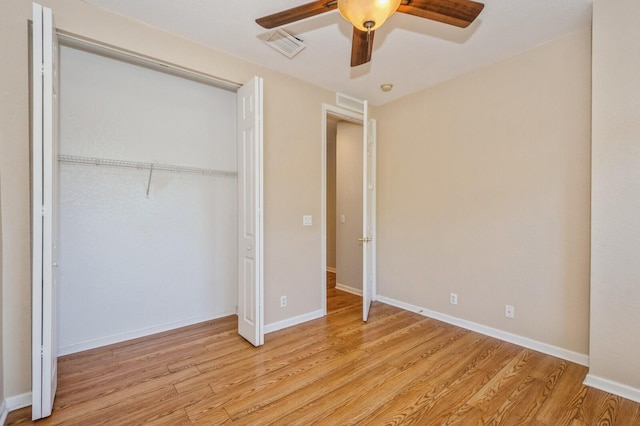 unfurnished bedroom featuring ceiling fan, a closet, and light wood-type flooring