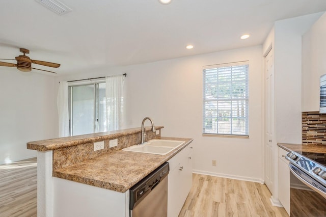 kitchen featuring backsplash, sink, white cabinets, and stainless steel appliances