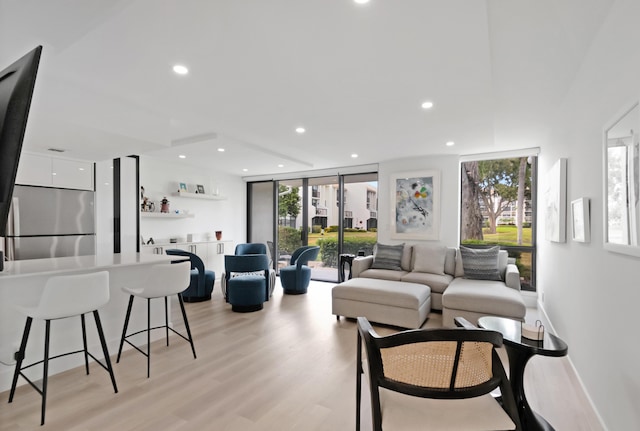 living room featuring bar area and light hardwood / wood-style flooring