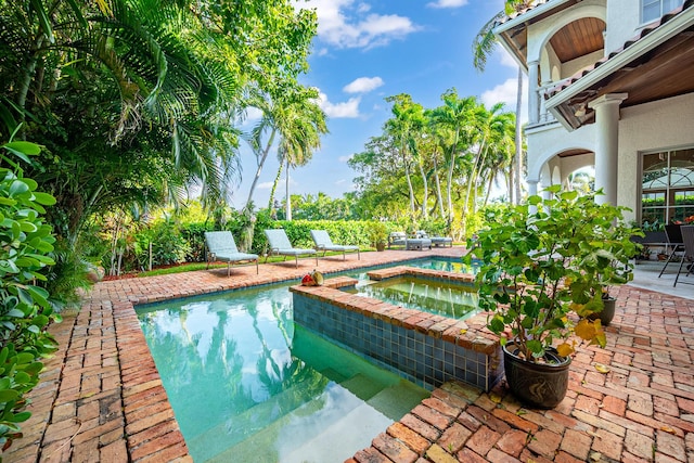 view of pool featuring a patio area and an in ground hot tub