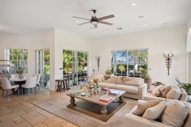 living room featuring ceiling fan, ornamental molding, and a high ceiling