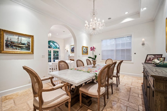 dining room with a raised ceiling, ornamental molding, and a chandelier