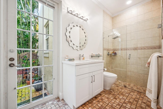 bathroom featuring crown molding, vanity, a shower with shower door, and toilet