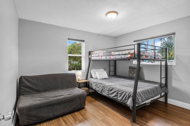 bedroom with hardwood / wood-style floors and a textured ceiling