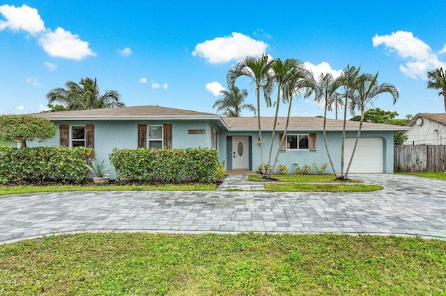 ranch-style home with a garage and a front lawn