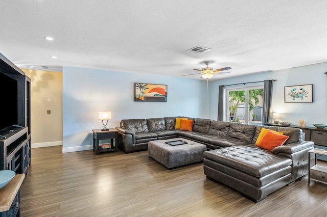 living room featuring a textured ceiling, hardwood / wood-style flooring, and ceiling fan