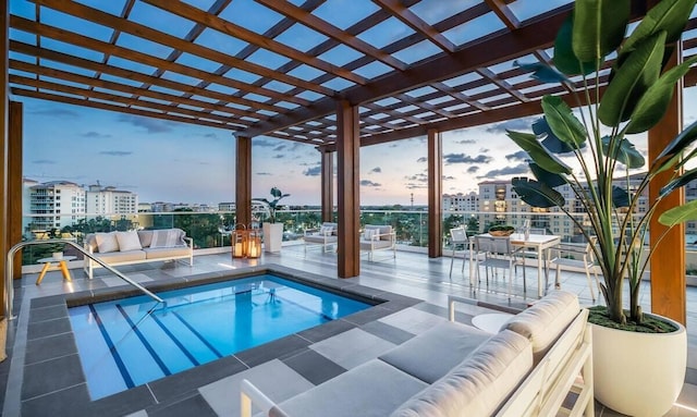 pool at dusk featuring a pergola and an outdoor hangout area