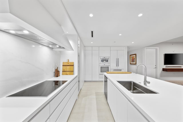 kitchen featuring custom exhaust hood, black electric stovetop, sink, double oven, and white cabinetry