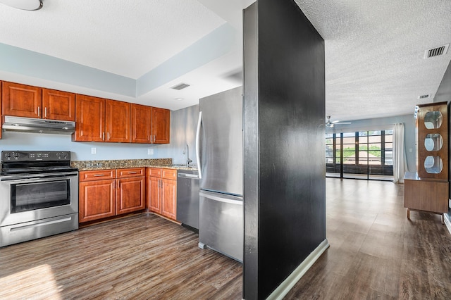 kitchen with light stone countertops, ceiling fan, sink, stainless steel appliances, and dark hardwood / wood-style flooring