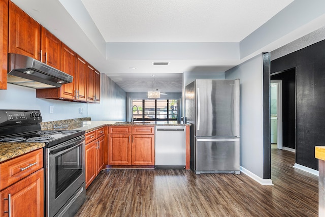 kitchen with pendant lighting, dark hardwood / wood-style floors, a textured ceiling, light stone counters, and stainless steel appliances