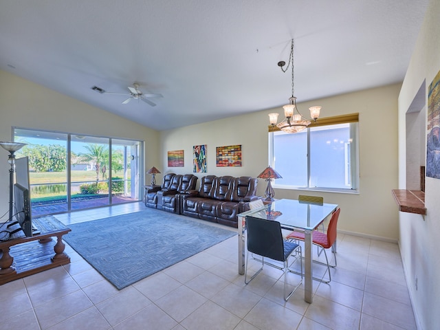 dining room featuring ceiling fan with notable chandelier, light tile patterned floors, and lofted ceiling