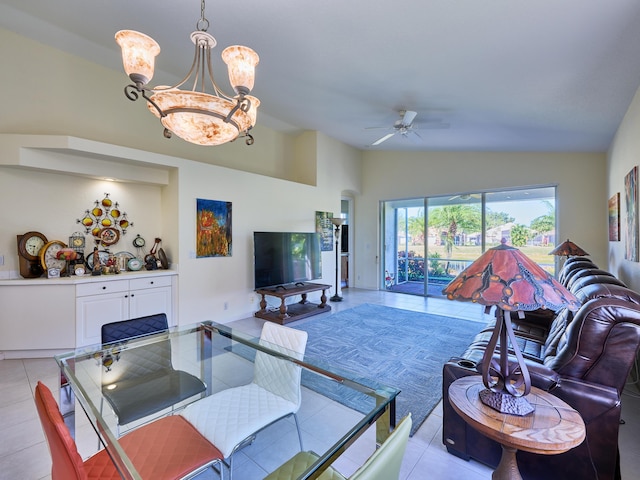 living room featuring light tile patterned floors, ceiling fan with notable chandelier, and vaulted ceiling