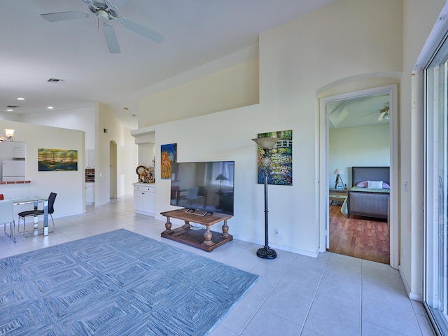 living room featuring ceiling fan, light tile patterned flooring, and lofted ceiling