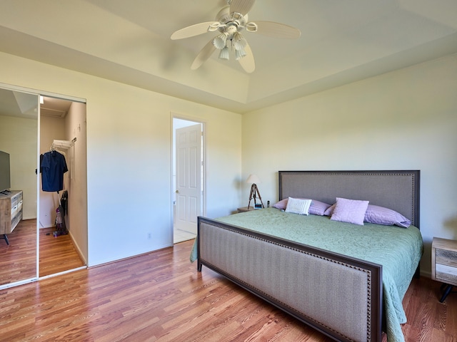 bedroom with ceiling fan, wood-type flooring, and a closet