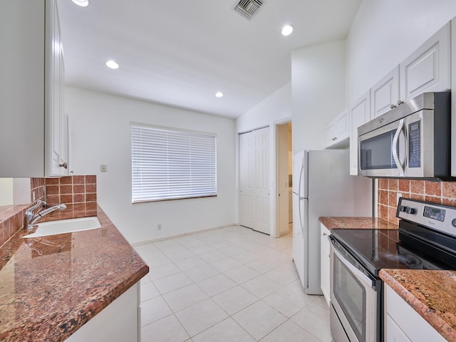 kitchen featuring sink, decorative backsplash, light tile patterned flooring, white cabinetry, and stainless steel appliances