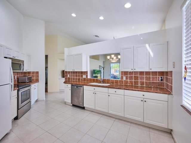 kitchen with white cabinets, appliances with stainless steel finishes, light tile patterned flooring, and sink