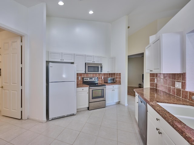 kitchen with white cabinets, appliances with stainless steel finishes, and light tile patterned floors