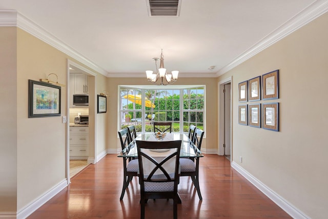 dining room with visible vents, crown molding, an inviting chandelier, and hardwood / wood-style floors