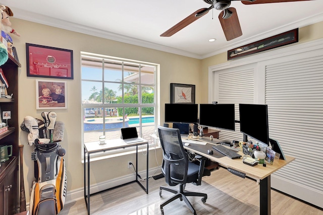 office featuring light wood-type flooring, baseboards, ornamental molding, and a ceiling fan