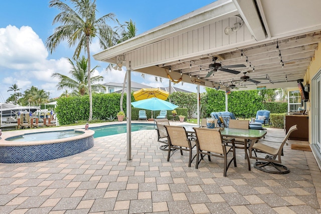 view of pool with a patio area, outdoor dining space, a pool with connected hot tub, and a ceiling fan