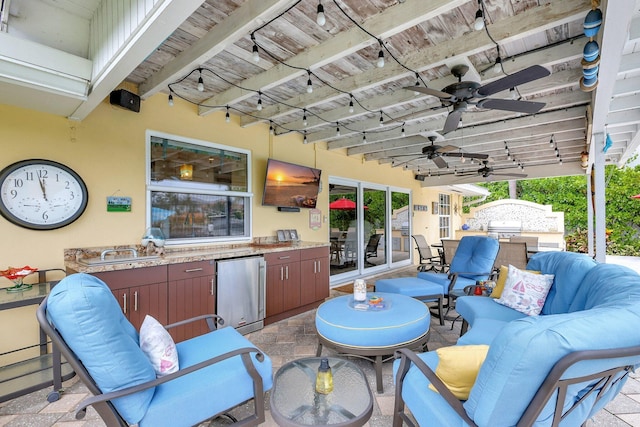 view of patio featuring an outdoor hangout area, exterior kitchen, ceiling fan, and a sink