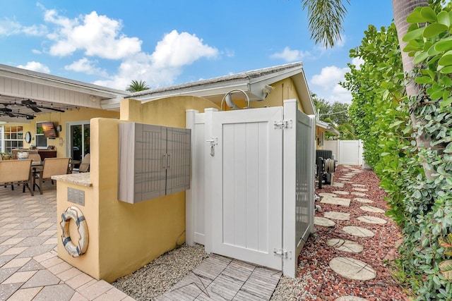 view of outbuilding featuring outdoor dining area, a gate, and fence