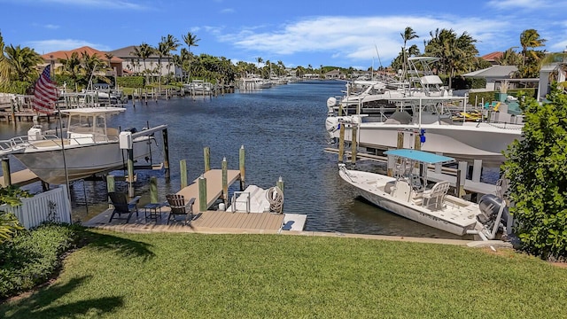 dock area with a water view, boat lift, and a lawn