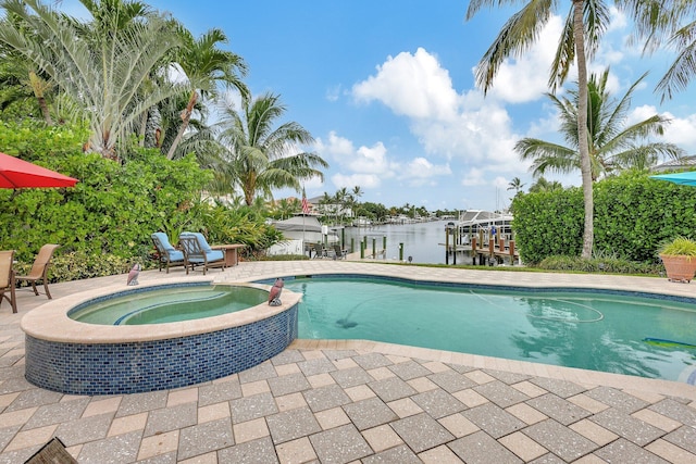 view of swimming pool with a patio area, a water view, a pool with connected hot tub, and a boat dock