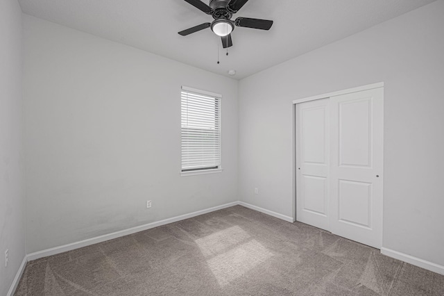 unfurnished bedroom featuring carpet flooring, ceiling fan, and a closet