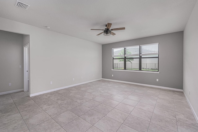 unfurnished room with ceiling fan, light tile patterned floors, and a textured ceiling