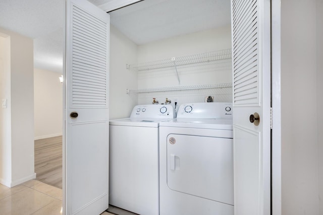 washroom with independent washer and dryer and light hardwood / wood-style floors