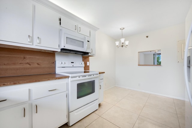 kitchen featuring white appliances, an inviting chandelier, white cabinets, hanging light fixtures, and light tile patterned floors