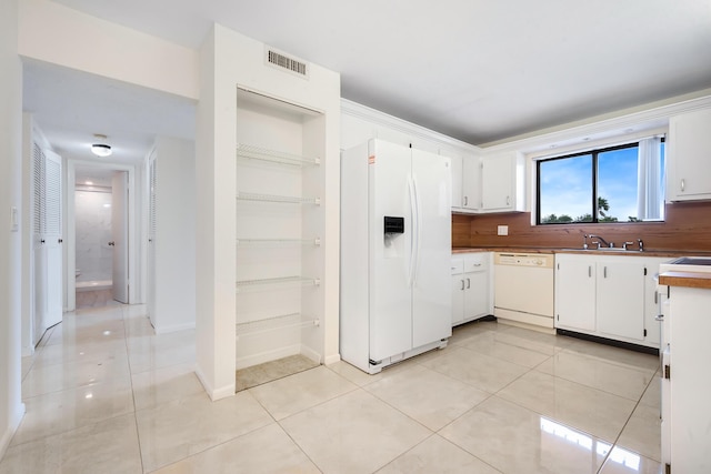 kitchen featuring sink, white appliances, white cabinetry, and light tile patterned flooring