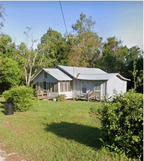 back of house featuring a lawn and a sunroom